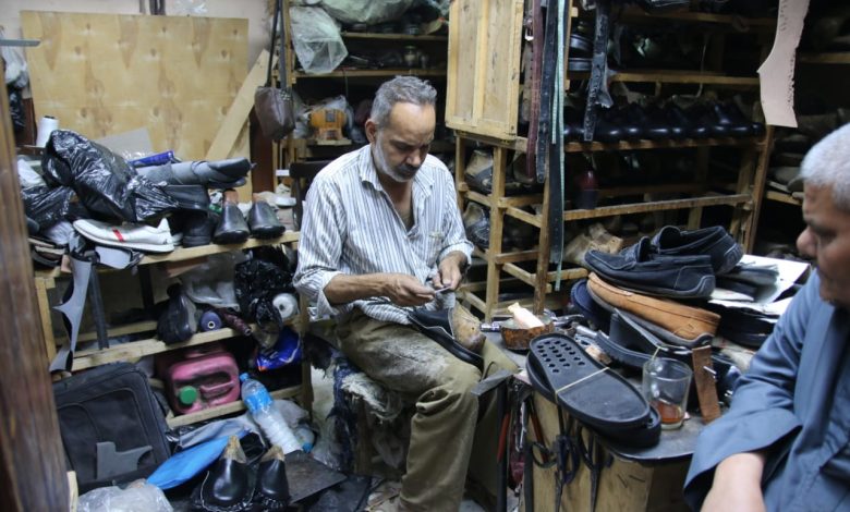 Hany, a master cobbler, meticulously repairs footwear within the vibrant arteries of Luxor’s Market Street. Photo: Abul-Hassan Abdulsattar